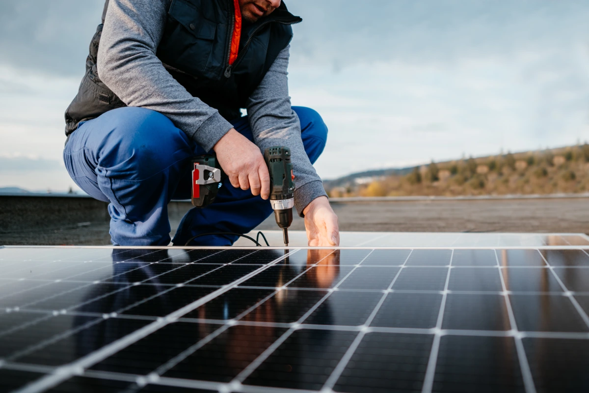 Worker installing solar panels on roof.